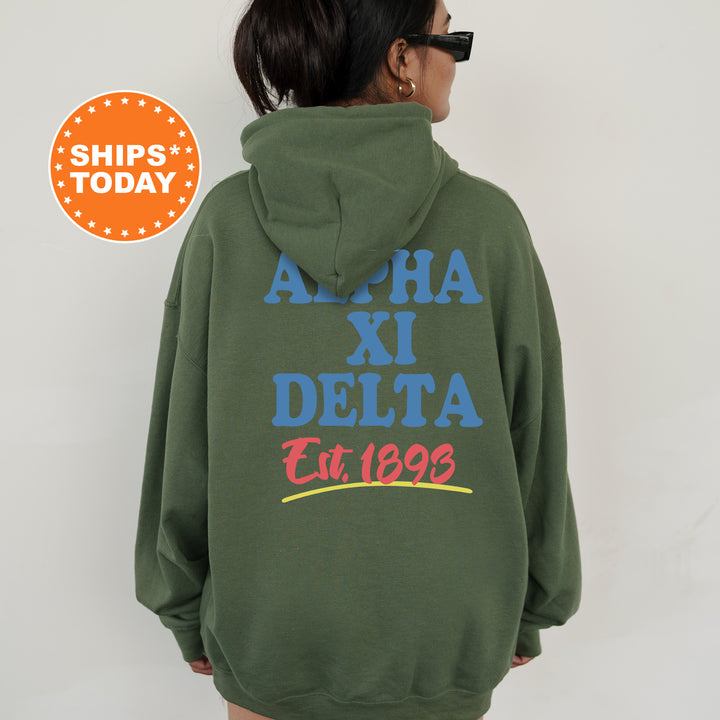 A person wearing a green hoodie with text and logos printed on the back.