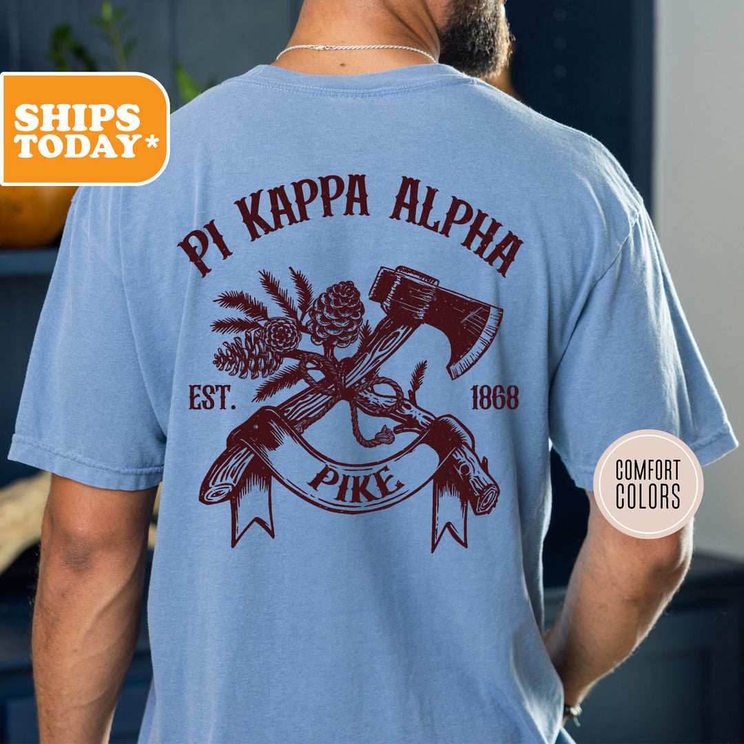 a man wearing a blue shirt with a hammer and pine cone on it