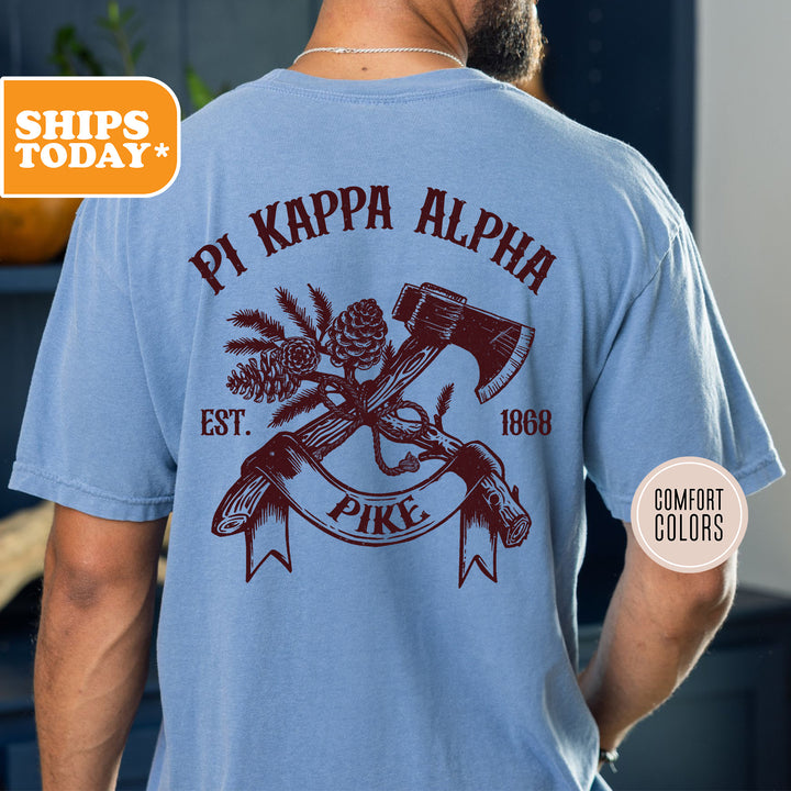 a man wearing a blue shirt with a hammer and pine cone on it