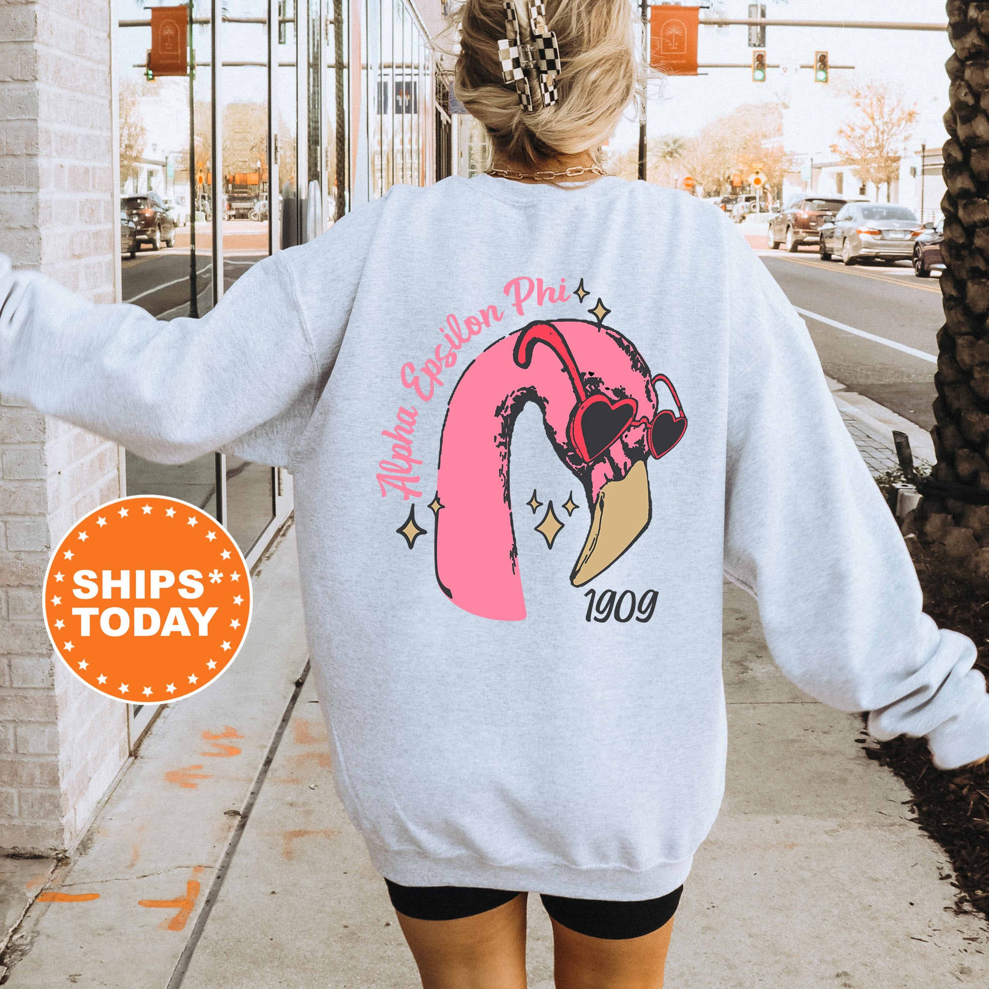 a woman walking down a sidewalk wearing a sweatshirt
