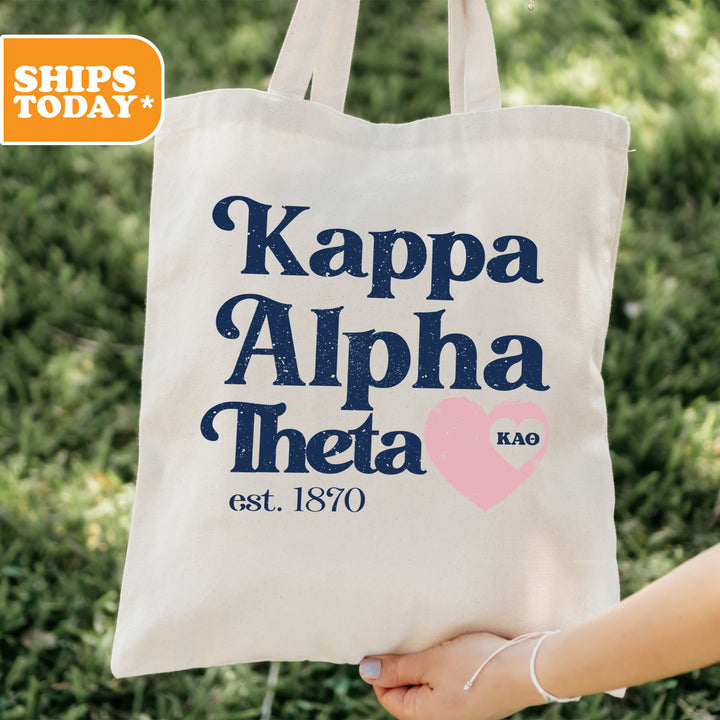 a person holding a tote bag that says kappa alpha thea