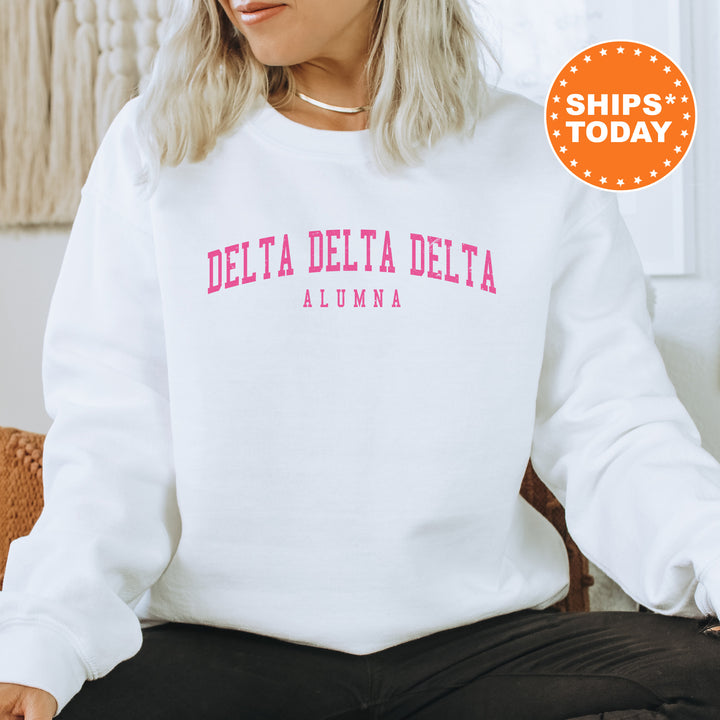a woman sitting on a chair wearing a white delta delta sweatshirt