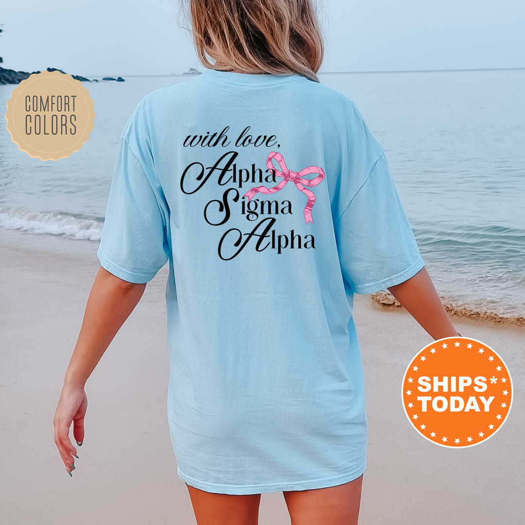 a woman walking on the beach wearing a light blue shirt