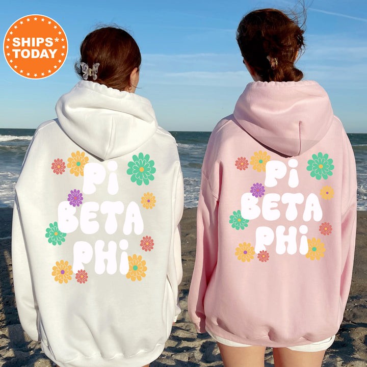 two women wearing matching sweatshirts on the beach