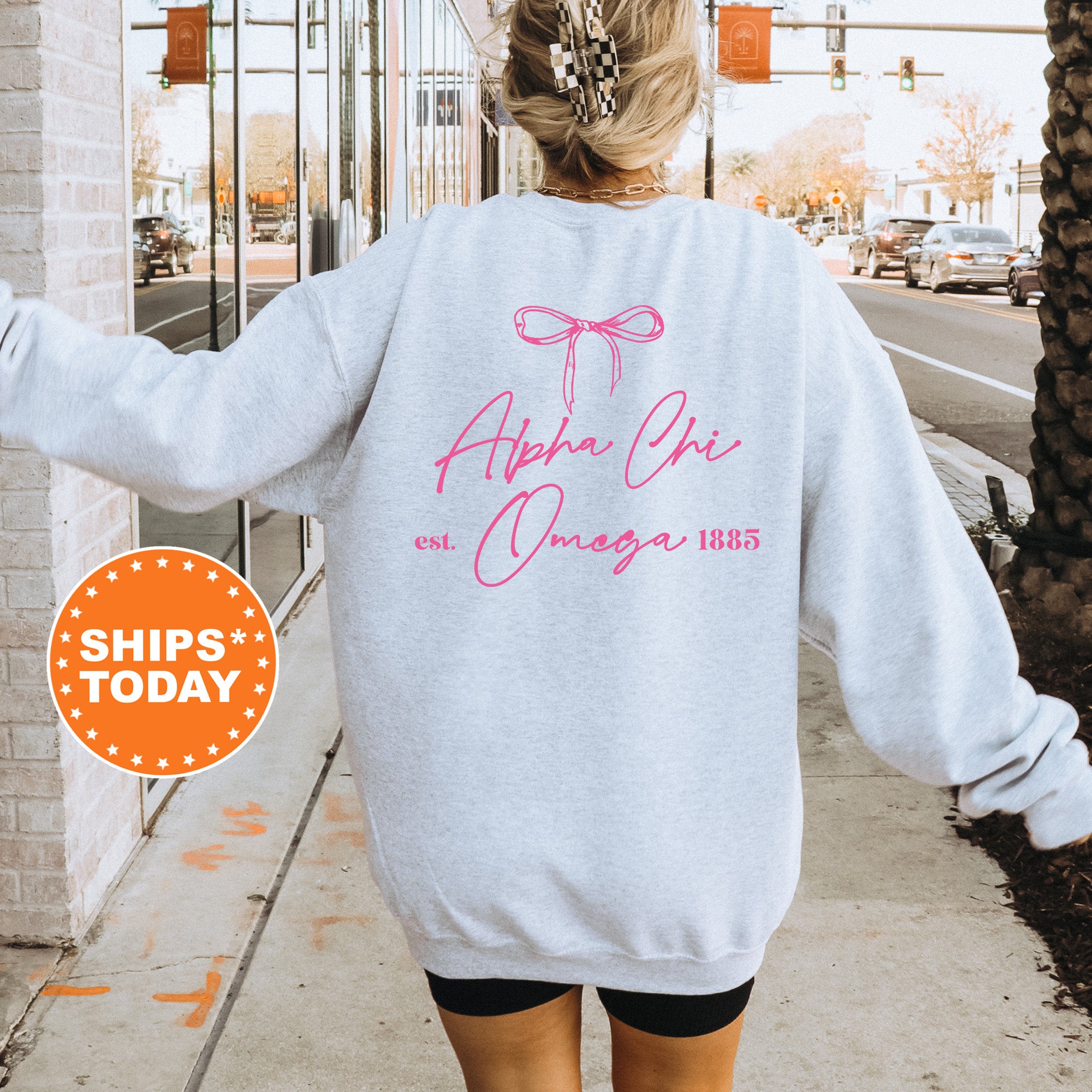 a woman walking down a sidewalk wearing a sweatshirt