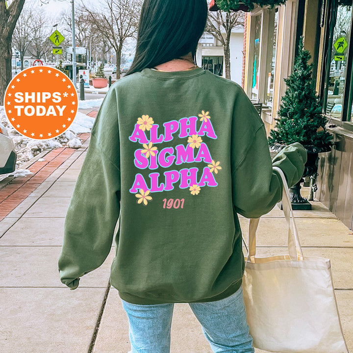 A person wearing a green sweatshirt with the text "ALPHA SIGMA ALPHA" printed on it, walking on a sidewalk.