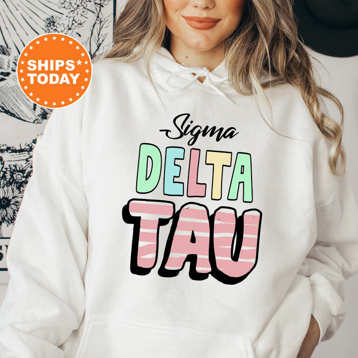 a woman wearing a white hoodie with the words delta tau on it