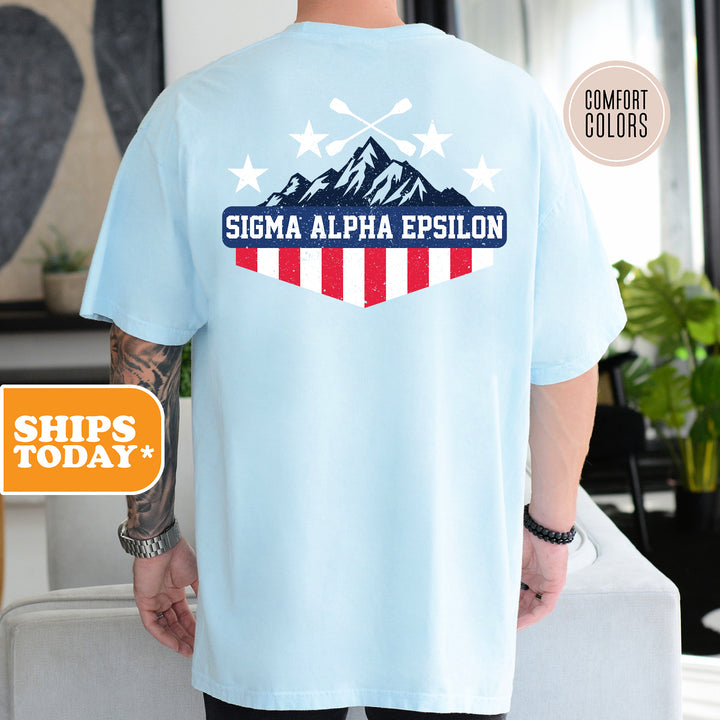 a man wearing a blue shirt with a mountain on it