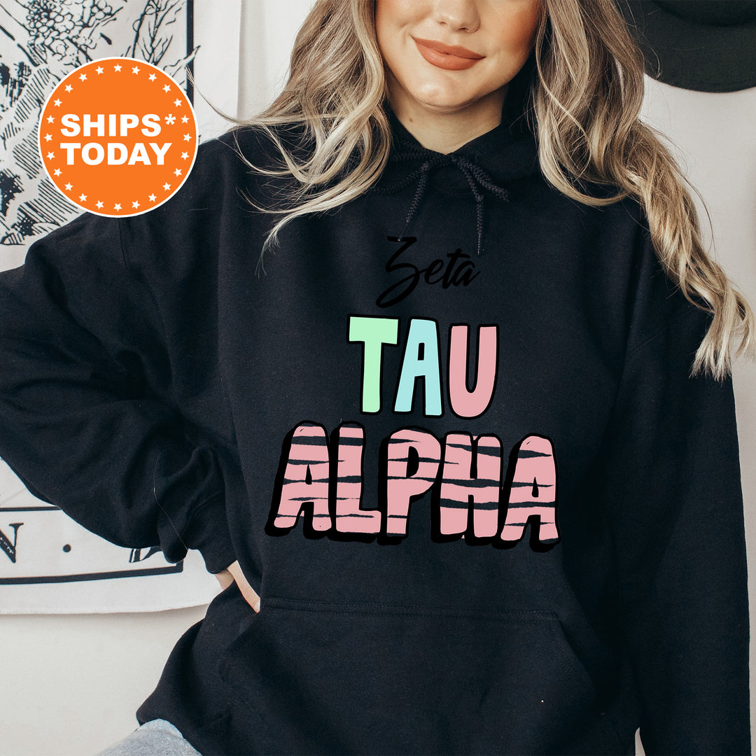 a woman wearing a black hoodie with the word tau alpia printed on it