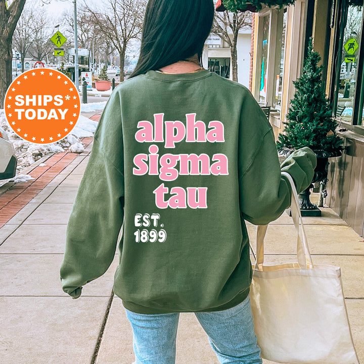 A person wearing a green sweatshirt with text on the back is walking on a sidewalk.
