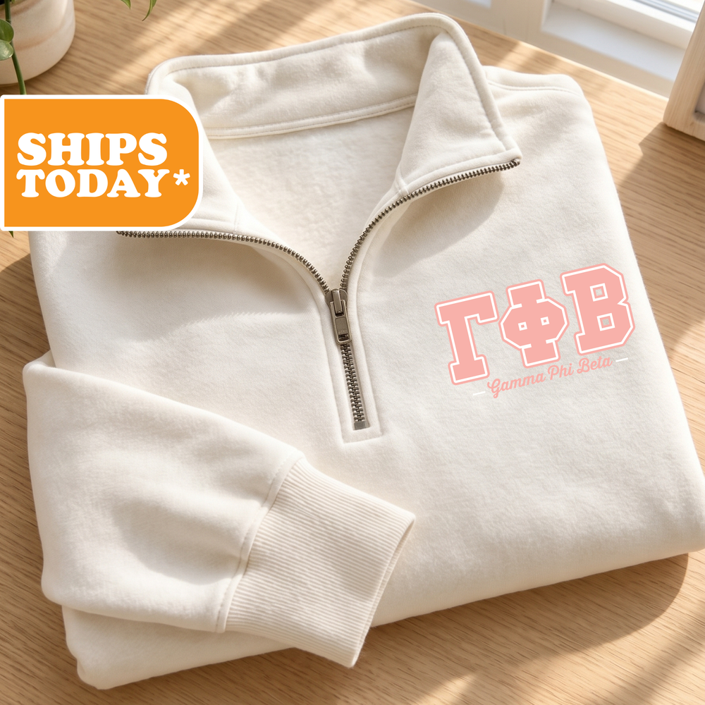 A white zip-up jacket with the letters "T&B" printed on it, placed on a wooden surface.