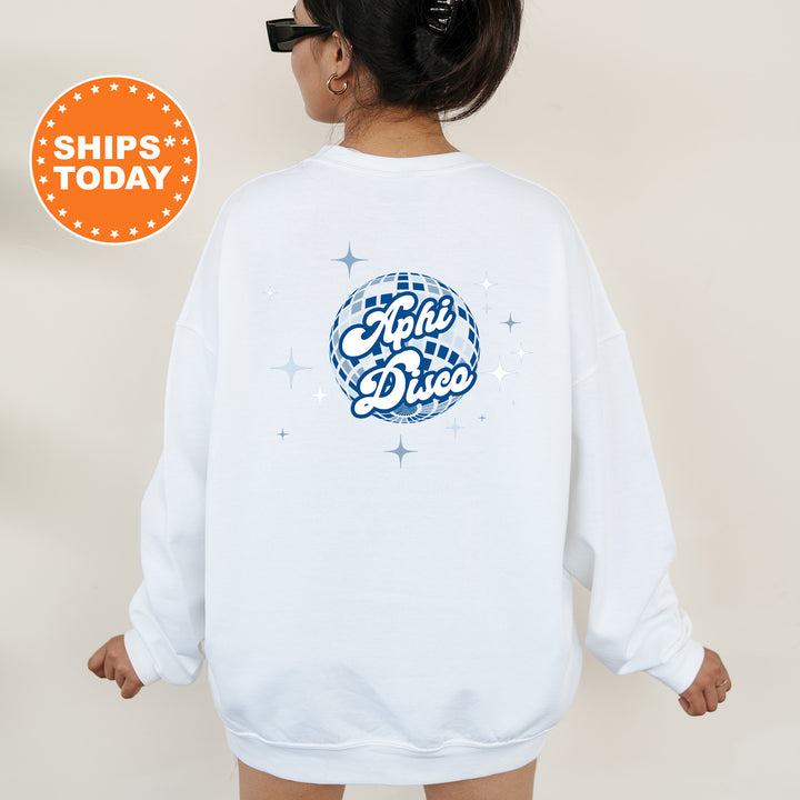 A person wearing a white sweatshirt with a graphic design on the back, including a disco ball and stars.