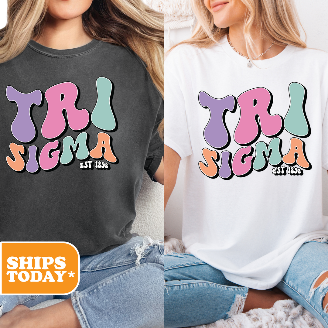 two women wearing matching tshirts sitting on a bed
