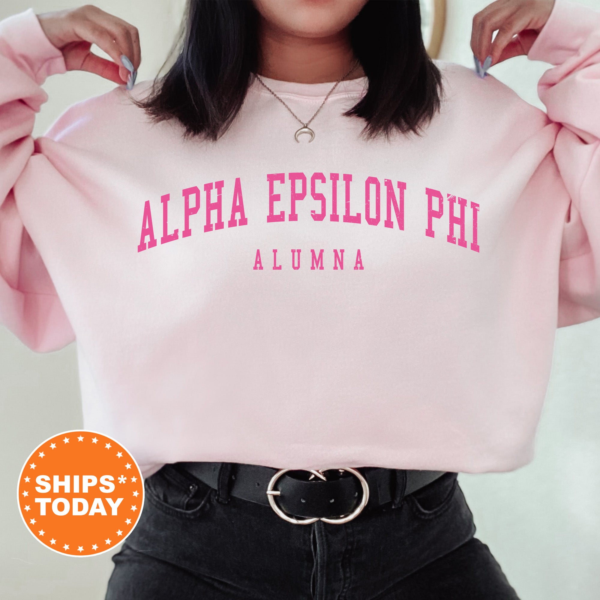a woman wearing a pink sweatshirt with the words, alpha epiloon phi on
