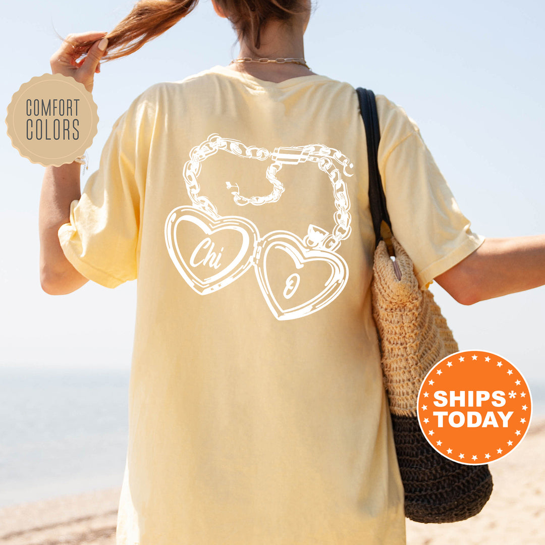 A woman wearing a yellow t-shirt with a graphic design on the back, standing on a beach with her hair in a ponytail.