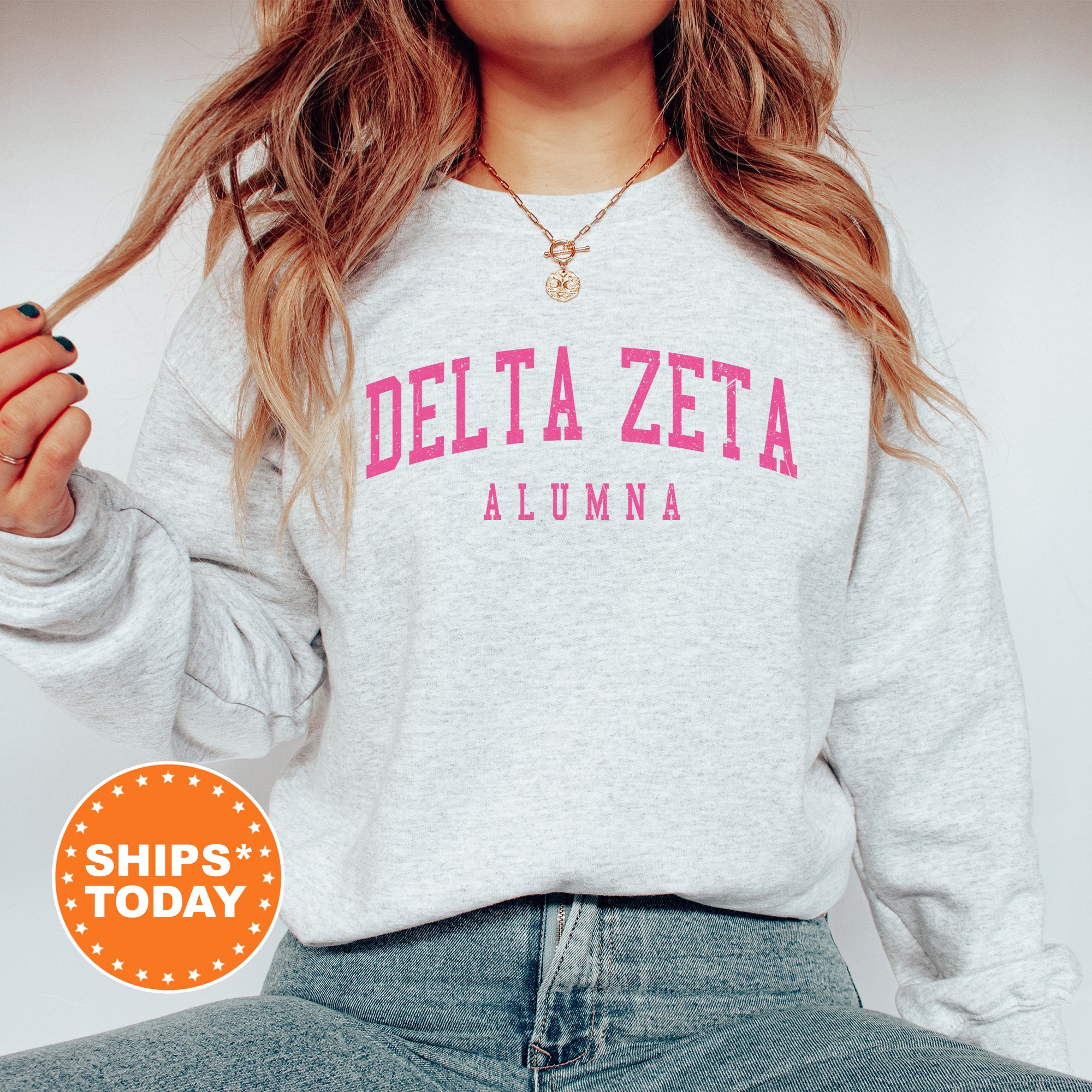 a woman with long hair wearing a delta delta sweatshirt