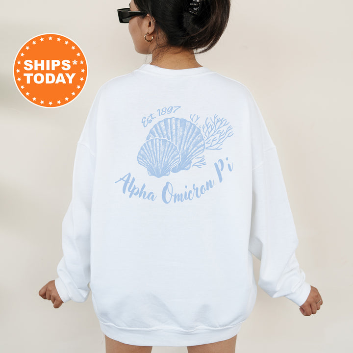 A woman wearing a white sweatshirt with a blue design and text on the back.