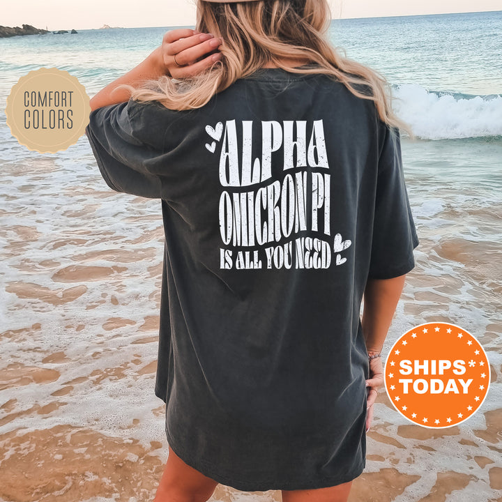 a woman standing on a beach wearing a black shirt