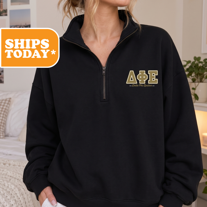A person wearing a black sweatshirt with a logo on the left side.