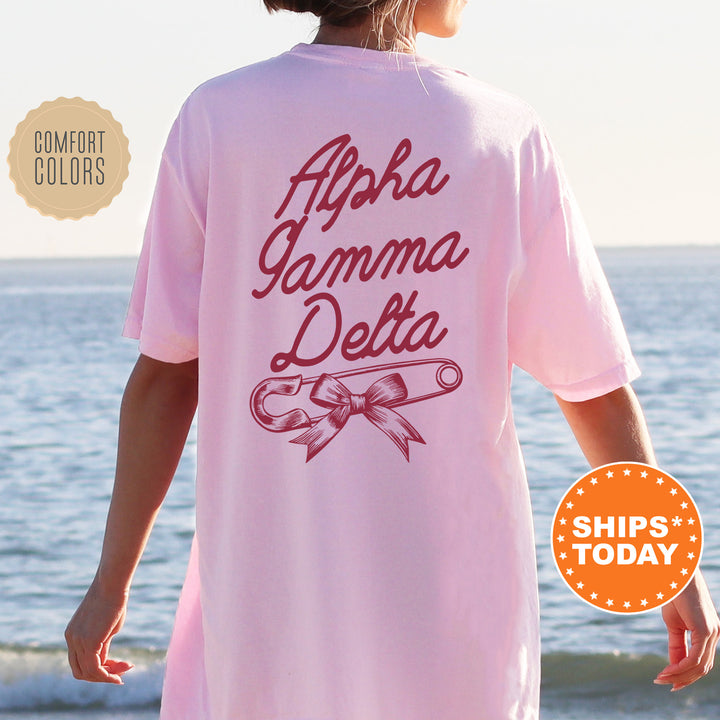 a woman standing on a beach wearing a pink shirt