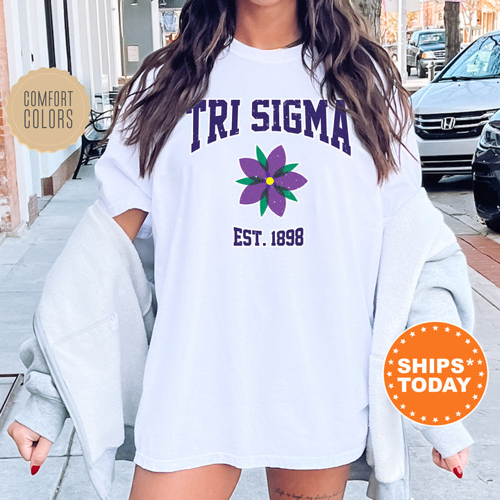 a woman wearing a white shirt with a flower on it