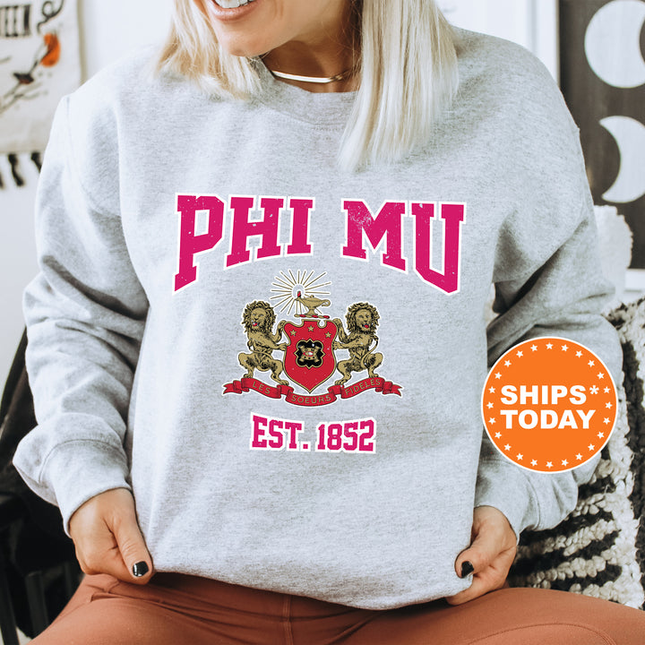 a woman sitting on a chair wearing a phi mu sweatshirt