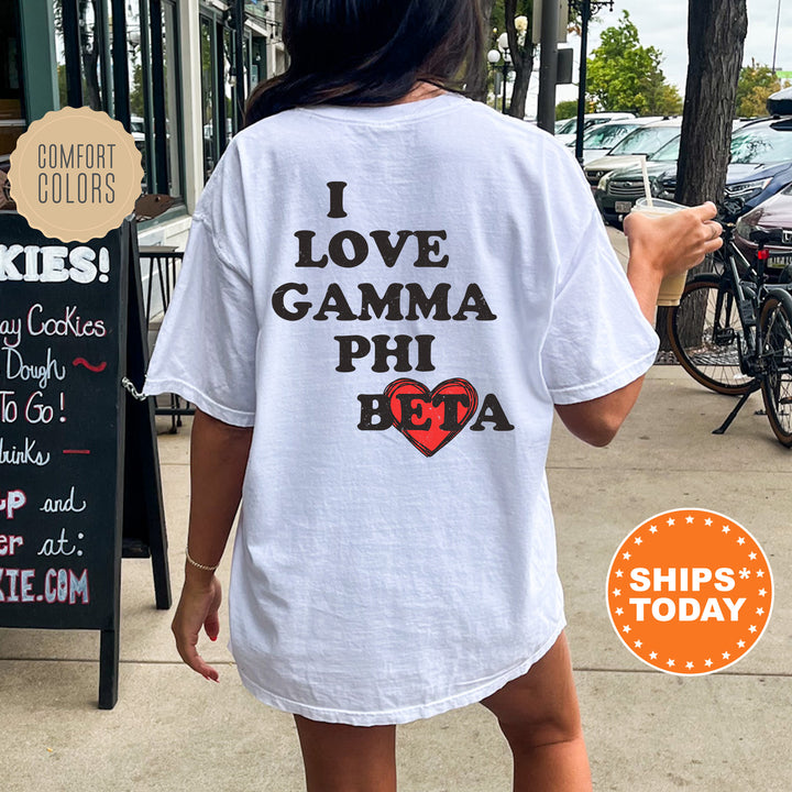 a woman walking down a sidewalk while wearing a t - shirt that says i love