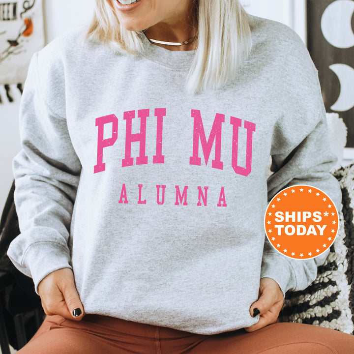 a woman sitting in a chair wearing a sweatshirt that says phi mu