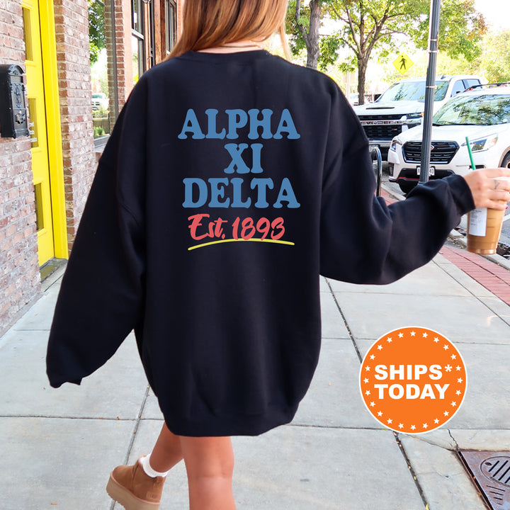 A person wearing a black sweatshirt with text and logos printed on it, walking on a sidewalk.