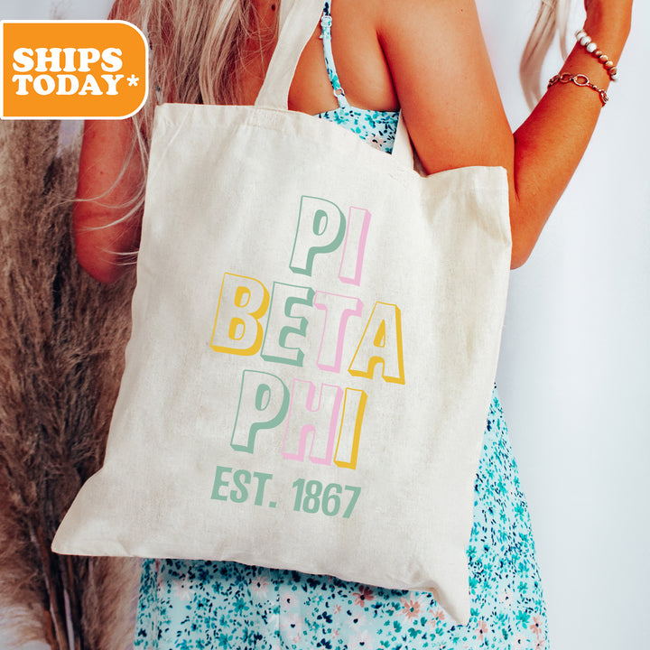 a woman holding a white bag with colorful letters on it