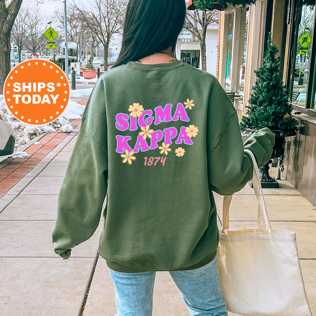 A person wearing a green sweatshirt with the Sigma Kappa logo and the year 1874 printed on it, walking on a sidewalk.