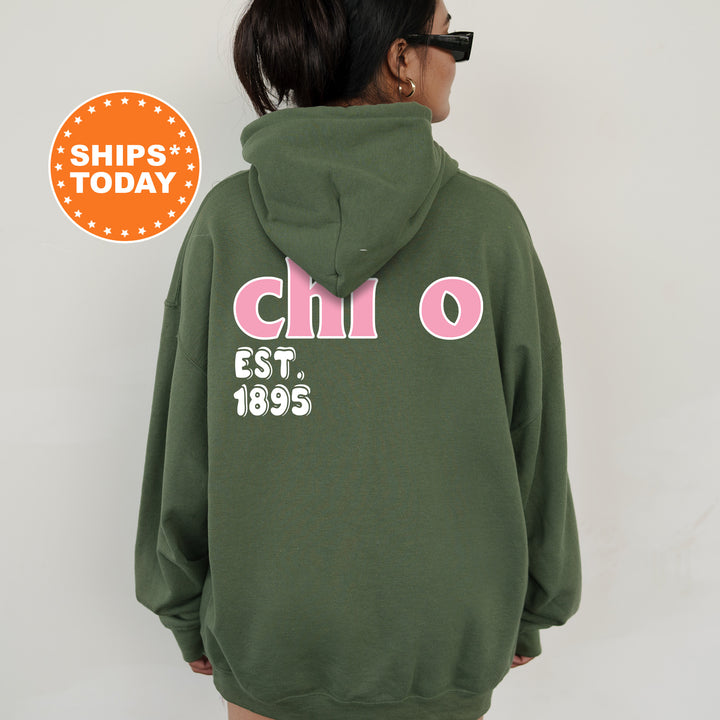 A person wearing a green hoodie with pink text and numbers on the back.