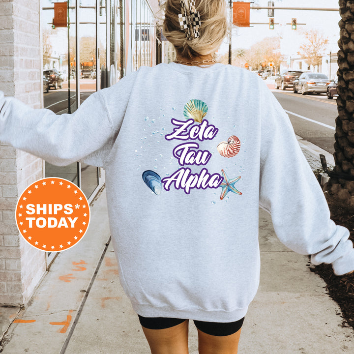 a woman walking down a sidewalk wearing a white sweatshirt