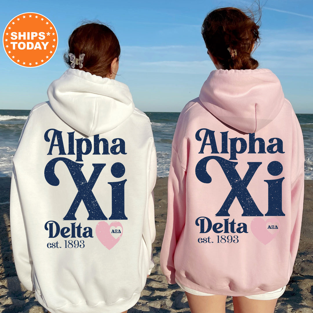 two women wearing pink and white hooded sweatshirts on the beach