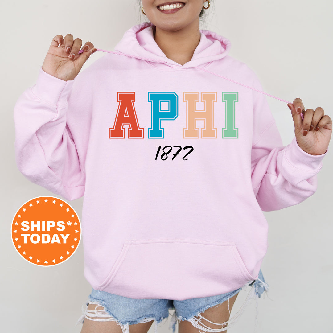 a woman wearing a pink hoodie with the word aphi on it