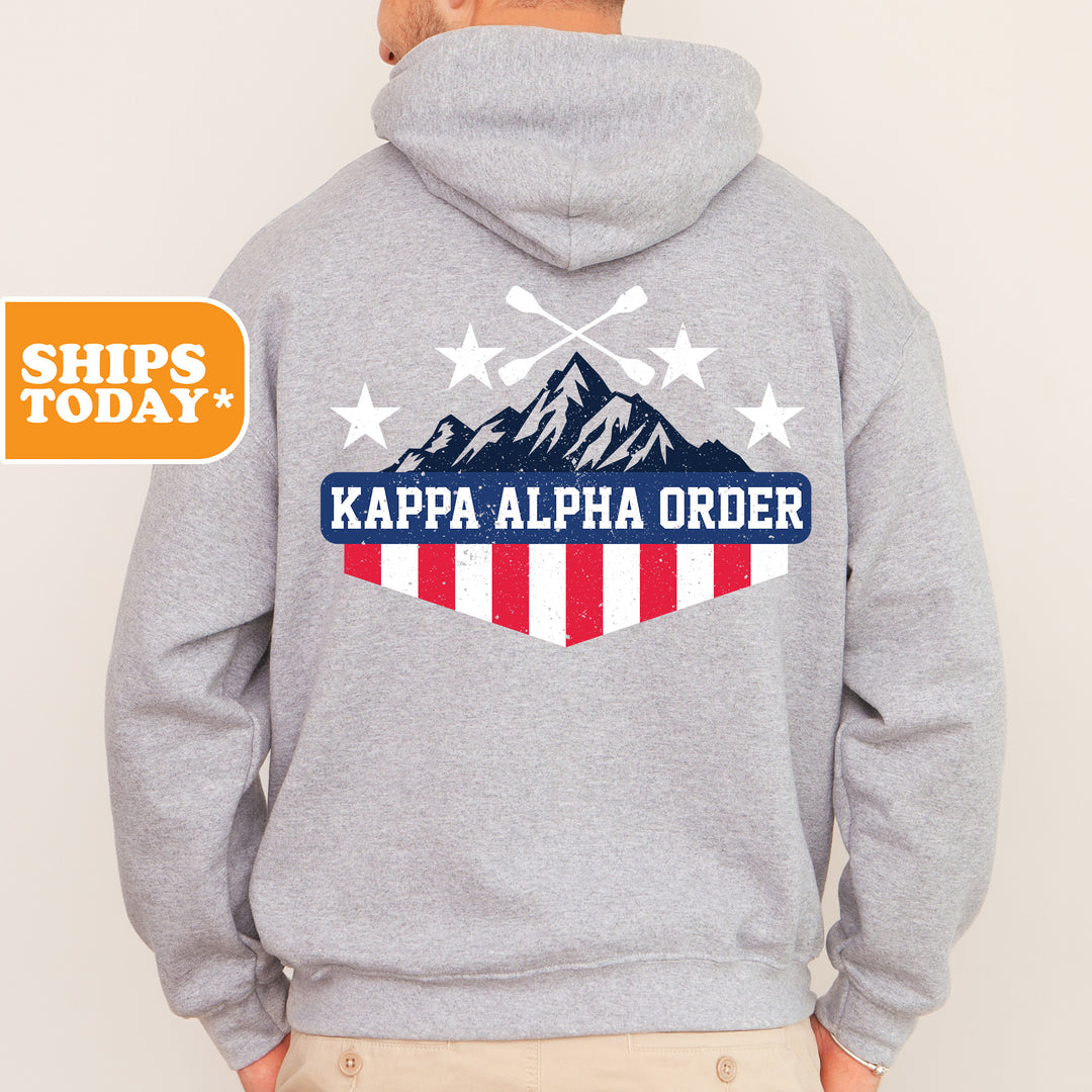 a man wearing a gray hoodie with a mountain and stars on it