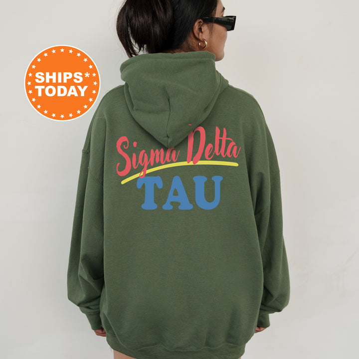 A person wearing a green hoodie with the text " Sigma Delta Tau" printed on it.