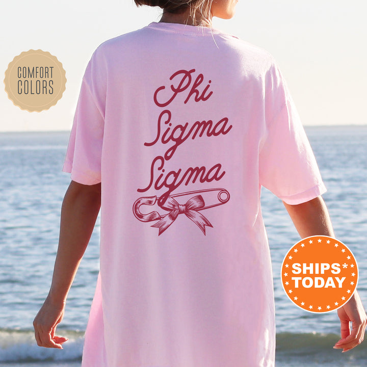 a woman standing on a beach wearing a pink shirt