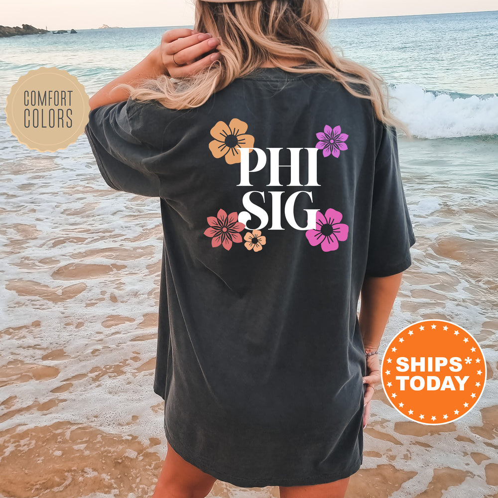 a woman standing on a beach wearing a phi sig shirt