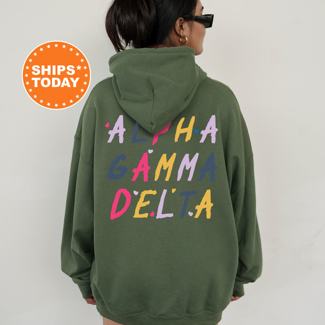 a woman wearing a green hoodie that says aha gamma delta