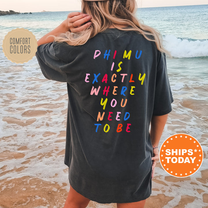 a woman standing on a beach wearing a black shirt