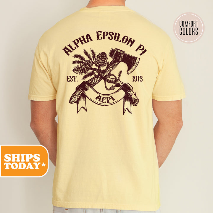 a man wearing a yellow shirt with an image of a hammer and a pine tree