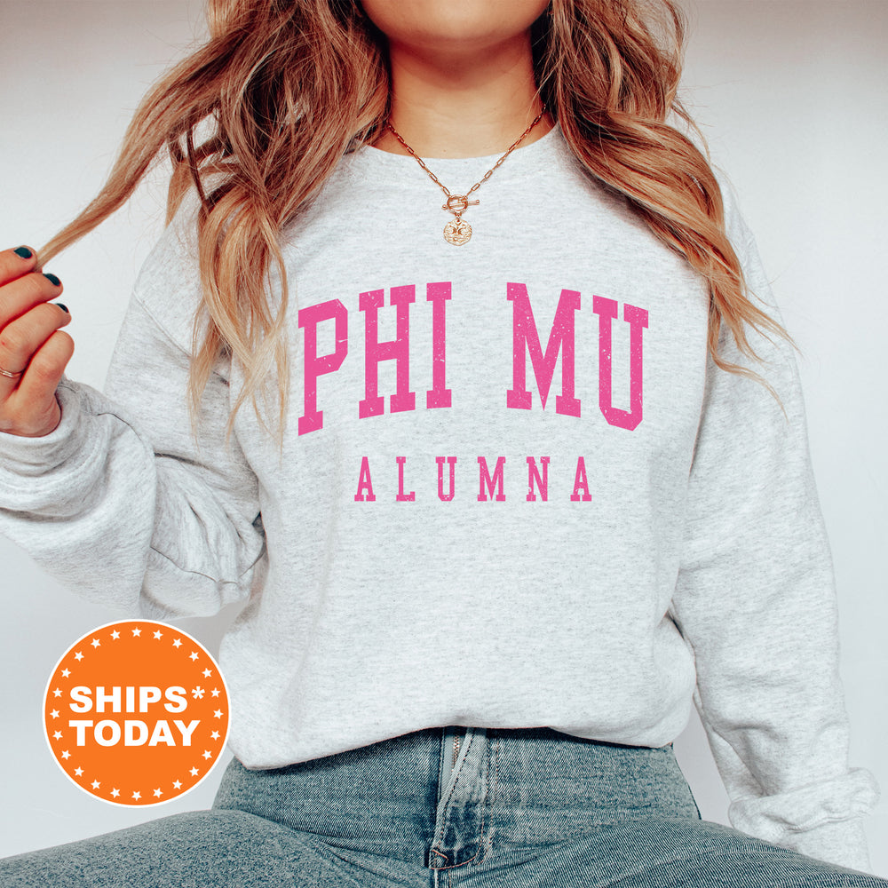 a woman wearing a sweatshirt that says phi mu aluma
