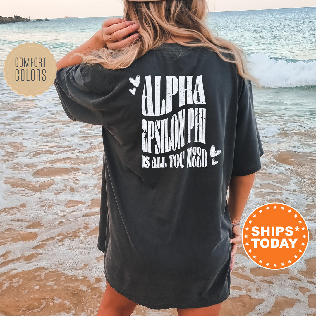 a woman standing on a beach wearing a black shirt