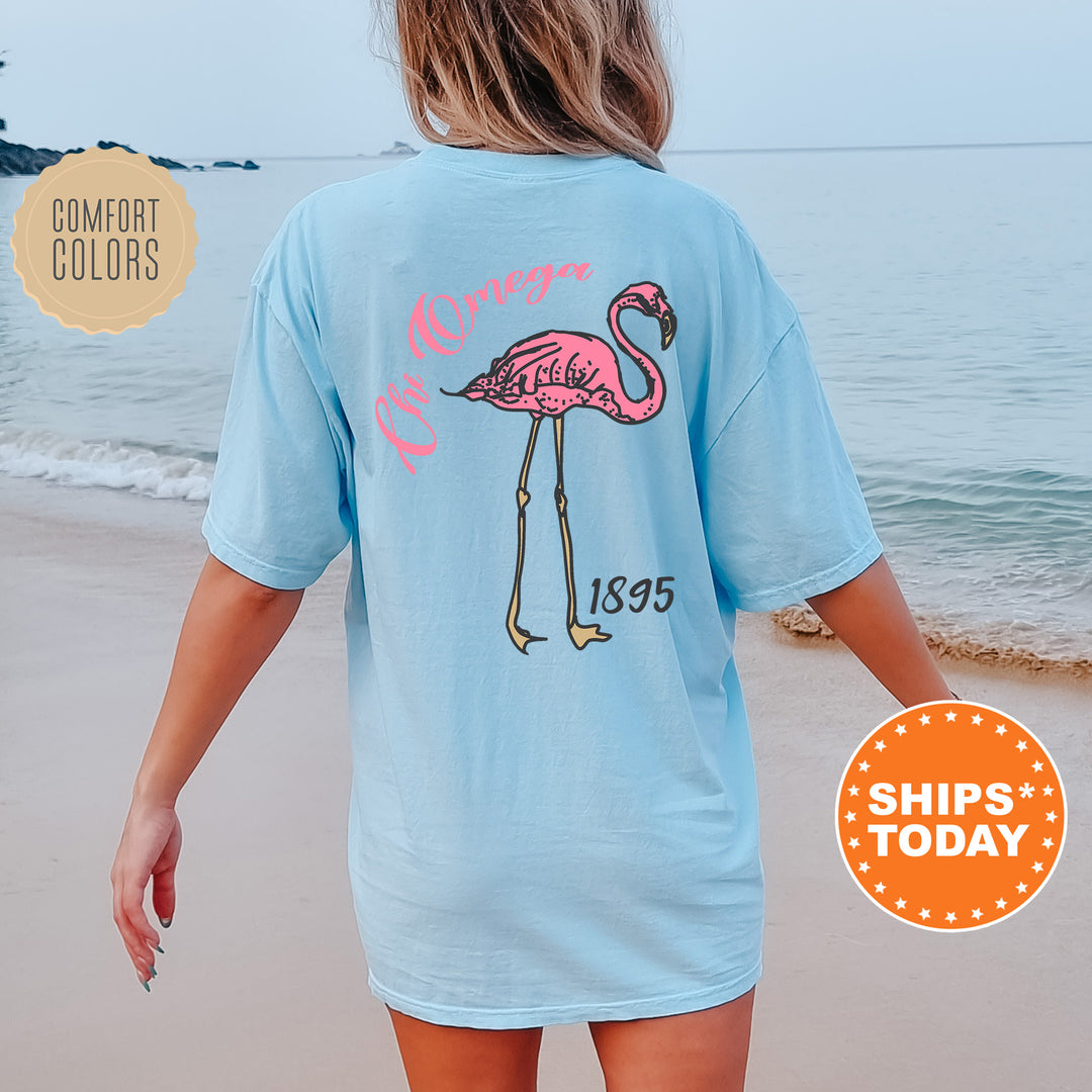 a woman walking on the beach with a pink flamingo t - shirt on