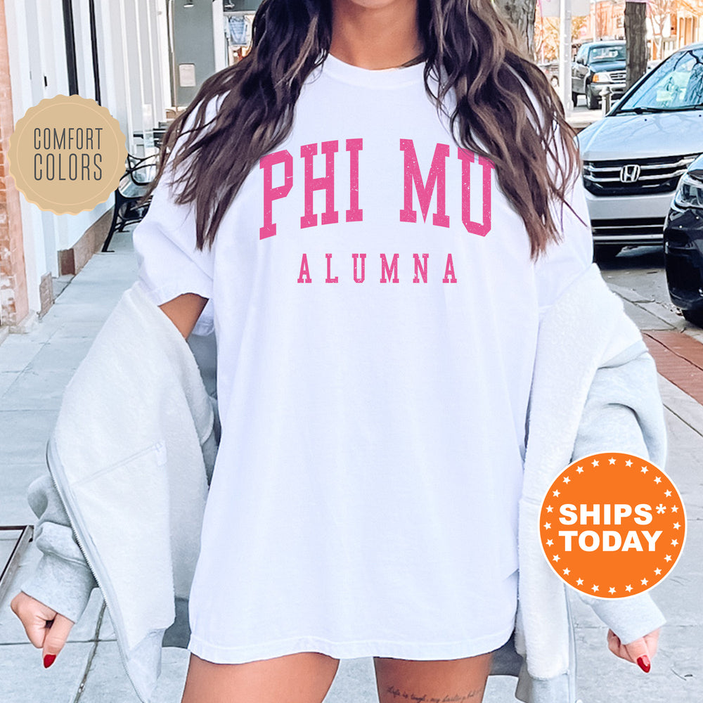 a woman wearing a white shirt with pink letters on it