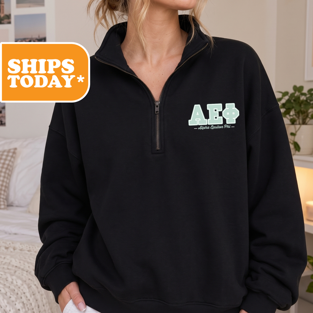 A person wearing a black sweatshirt with a logo on the left side.