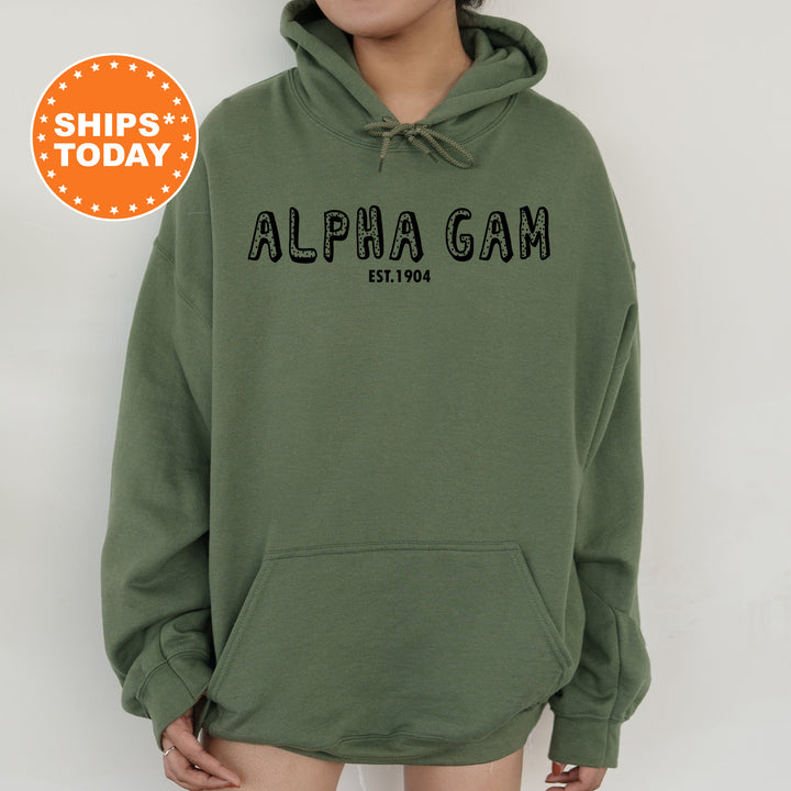 a woman wearing a green hoodie with the words alpha gam on it