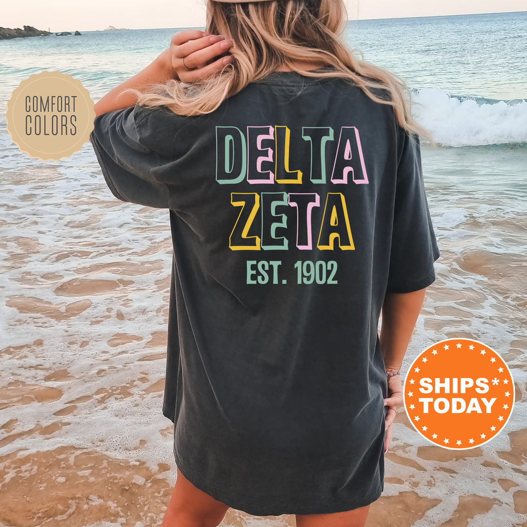 a woman standing on a beach wearing a black delta shirt
