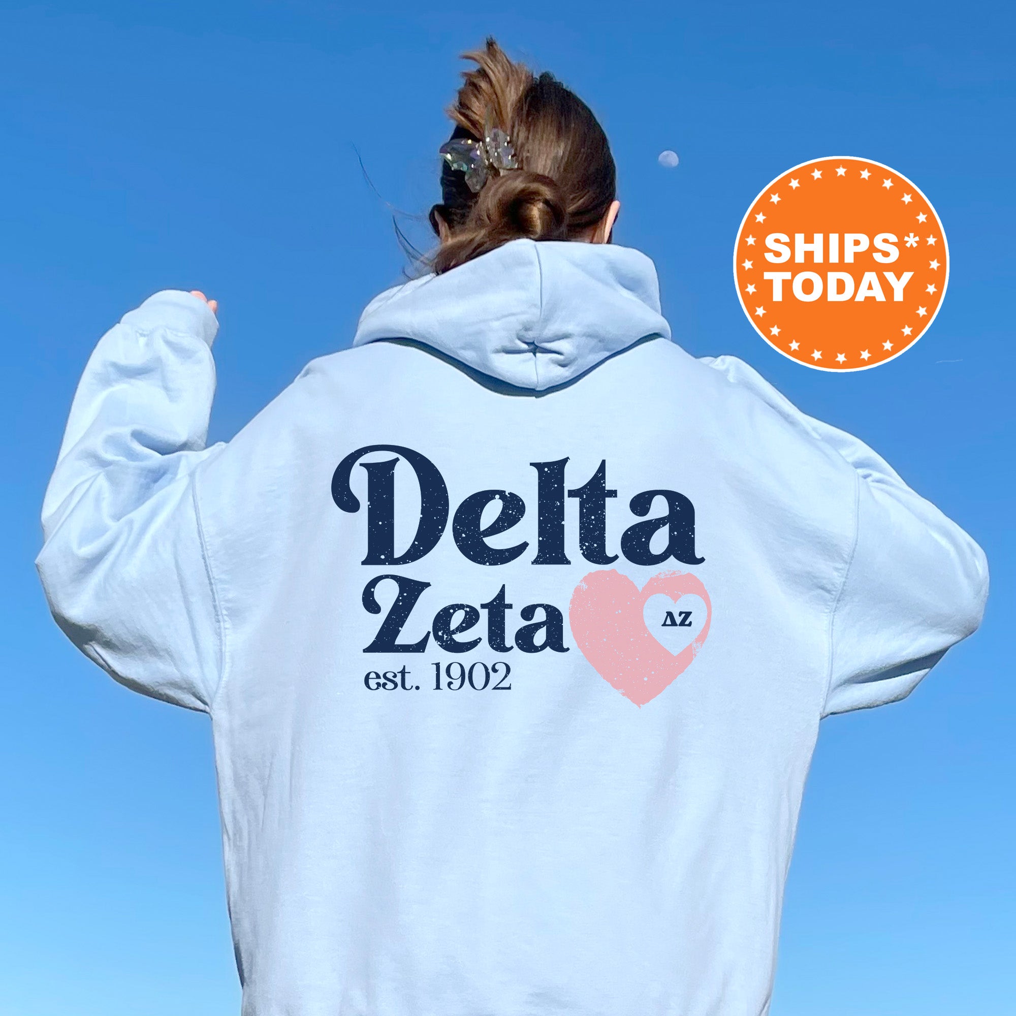 a woman with her back to the camera wearing a white delta sweatshirt